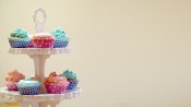 Roze en blauwe geboortecupcakes op een etagere